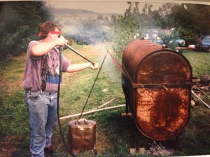 This is my dad keeping the temperature of the oil tank under control.  There's a whole pig in there!  It fed about 40 people.